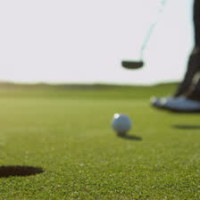 stock-footage-close-up-legs-feet-male-professional-golfer-using-putter-to-hole-the-ball-slow-motion-shot-on-red